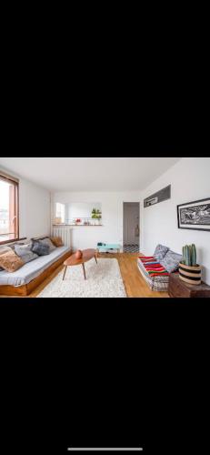 un salon avec un lit et un canapé dans l'établissement Home Sweet Home Parmentier, à Paris