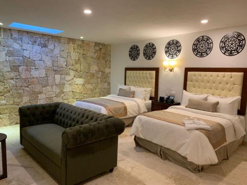 a hotel room with two beds and a couch at Real Hispano in Valladolid