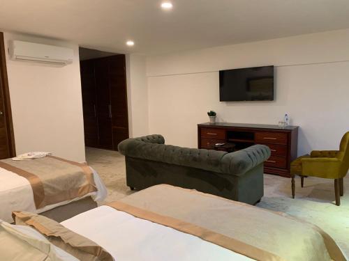 a hotel room with a couch and a tv at Real Hispano in Valladolid