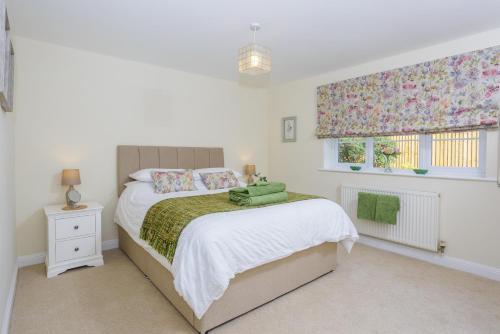 a bedroom with a bed and a window at Overbrook in Droitwich