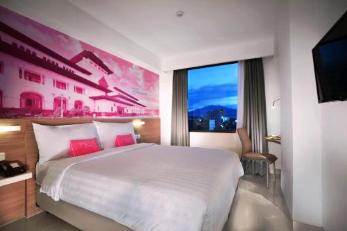 a bedroom with a large bed and a large window at favehotel Hyper Square in Bandung