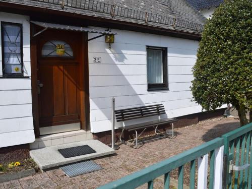 a door to a house with a bench in front of it at Holiday home in Ramsbeck with garden in Bestwig