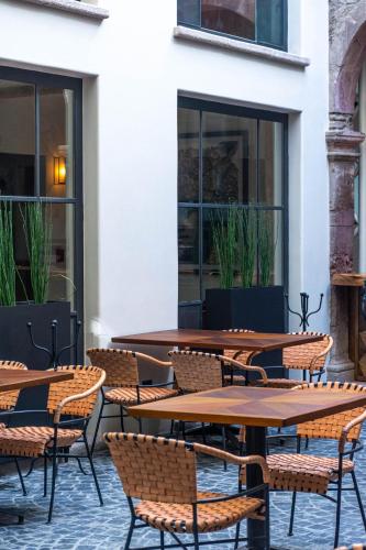 an outdoor patio with wooden tables and chairs at Casa 1810 Parque Hotel Boutique in San Miguel de Allende