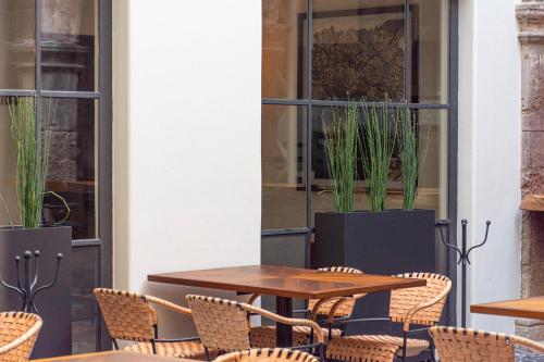 a patio with tables and chairs and potted plants at Casa 1810 Parque Hotel Boutique in San Miguel de Allende