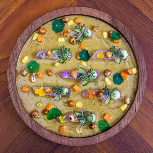 a wooden bowl of food on a wooden table at Casa 1810 Parque Hotel Boutique in San Miguel de Allende