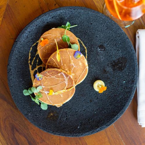 a black plate with a sandwich on a table at Casa 1810 Parque Hotel Boutique in San Miguel de Allende
