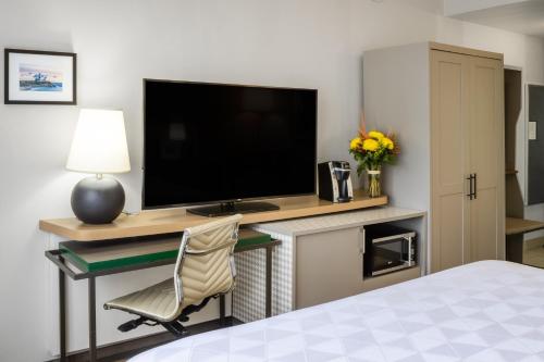 a hotel room with a desk with a television and a chair at Holiday Inn - Long Island - ISLIP Arpt East by IHG in Holtsville