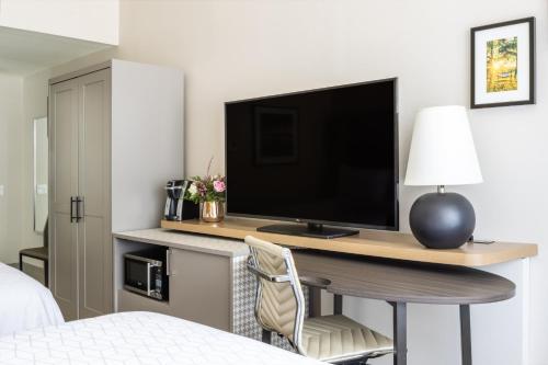 a bedroom with a desk with a television and a chair at Holiday Inn - Long Island - ISLIP Arpt East by IHG in Holtsville