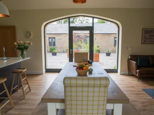 a living room with a table with a bowl of fruit on it at Stunning Edinburgh 1820s stables converted house in Ratho