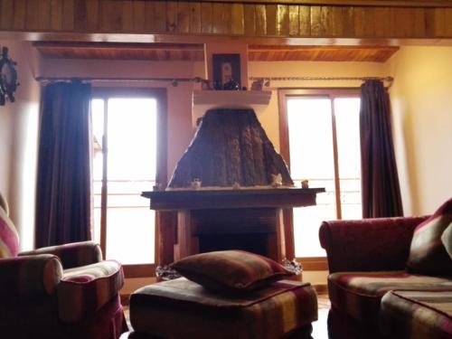 a living room with a fireplace and a couch at appartement chalet in Imouzzer Kandar