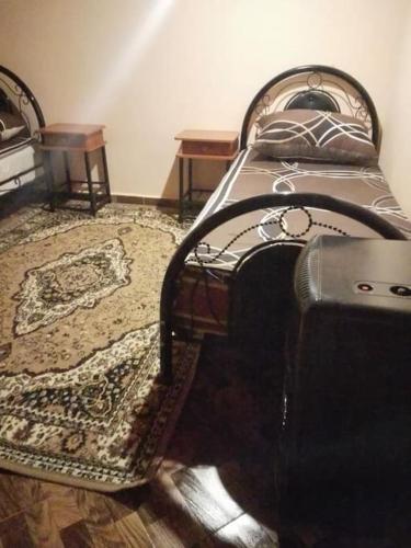 a bedroom with a bed and a rug at appartement chalet in Imouzzer Kandar