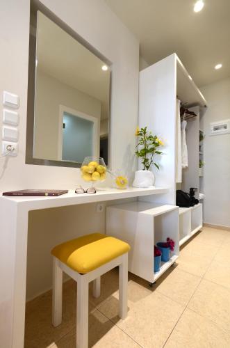 a bathroom with a counter with a yellow stool and a mirror at Kordistos Hotel in Kefalos