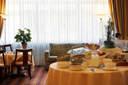 a table with bowls and plates of food on it at Hotel Victoria in Lausanne