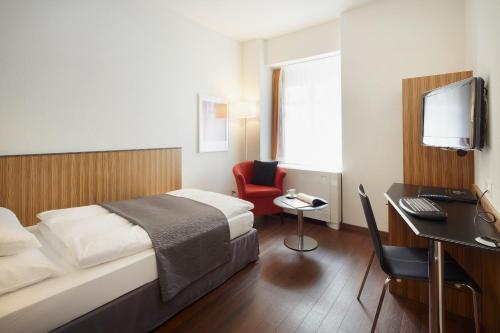 um quarto de hotel com uma cama e uma secretária com um computador em Sorell Hotel Rütli em Zürich