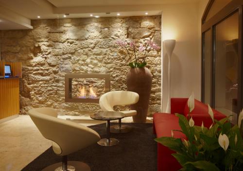 a living room with a stone wall with a fireplace at Sorell Hotel Rütli in Zurich