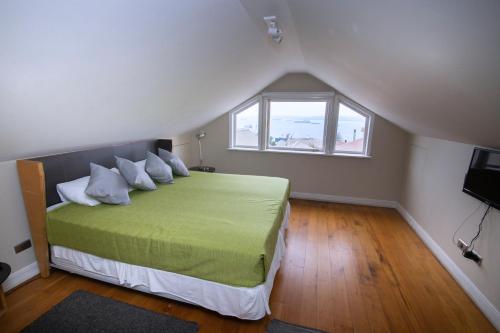 a bedroom with a green bed with a window at New Voga Hotel Boutique in Valparaíso