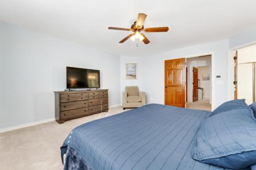Schlafzimmer mit einem blauen Bett und einem Deckenventilator in der Unterkunft Living Under Par in Phoenix