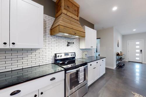 a kitchen with white cabinets and a stove top oven at Dry Creekside Casita in Fischer