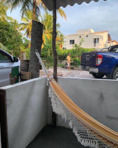 a hammock on the side of a house at Pousadinha da Lulu - Pontal Mangue Seco in Indiaroba