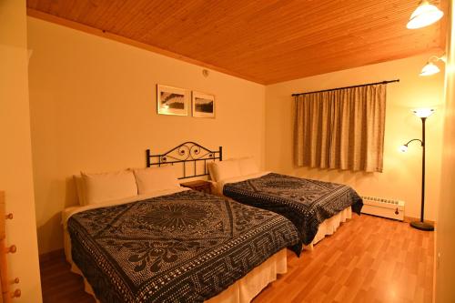 a hotel room with two beds in a room at Kaleido Lodge Yukon in Whitehorse