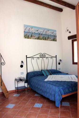 a bedroom with a bed with a blue comforter at La Casa del Geko in Cefalù