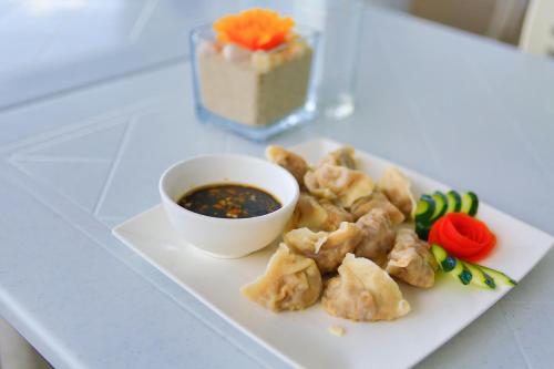 a plate of food with a bowl of dipping sauce at Arkipelago Divers and Beach Resort in Puerto Galera