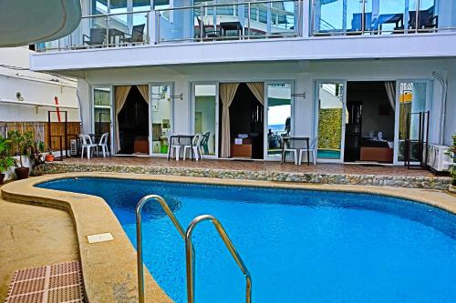 een groot zwembad voor een gebouw bij Arkipelago Beach Resort in Puerto Galera