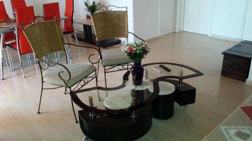 a table and chairs with a vase of flowers on it at Eva Apartments in Svoronata