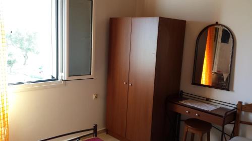 a bathroom with a wooden cabinet and a mirror at Eva Apartments in Svoronata