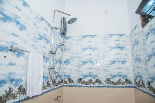 a bathroom with a shower with palm trees on the wall at Sadee's Place in Dambulla