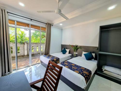 two beds in a room with a window at Airis Sanctuary Resort in Pantai Cenang