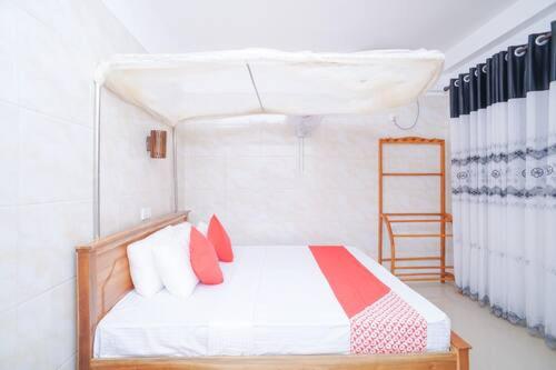 una camera da letto con un letto con cuscini rossi e una scala di Hotel Cranberry a Hikkaduwa
