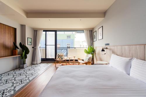a bedroom with a large bed and a balcony at I am here B&B in Tainan