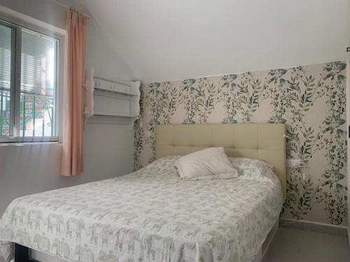 1 dormitorio con 1 cama y papel pintado con motivos florales en villa Cerro del Aguila, en Mijas Costa