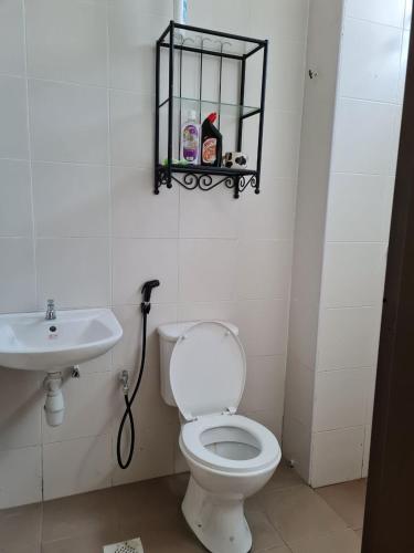 a bathroom with a toilet and a sink at Embon Homestay in Padang Serai