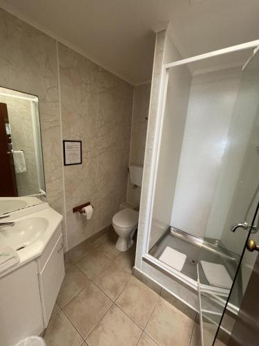 a bathroom with a shower and a toilet and a sink at Bay Sands Seafront Studios in Paihia