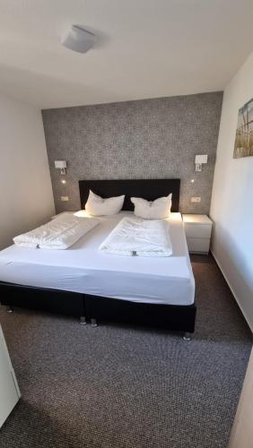 a bedroom with a large bed with white sheets and pillows at FeWo an der Ostsee Nr. 4 in Rerik