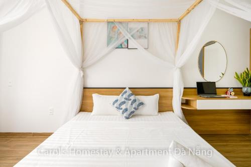 a bedroom with a white bed with a mirror at Carol Homestay & Apartment Da Nang 3 in Da Nang