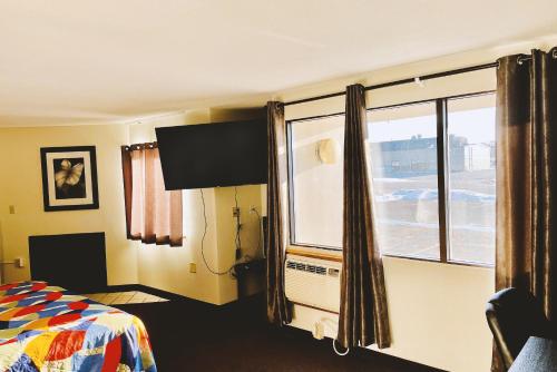 a hotel room with a bed and a window at Coratel Inn & Suites by Jasper Northfield in Northfield
