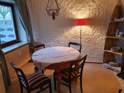 a table with chairs and a lamp in a room at Bi Henning in Nordstrand