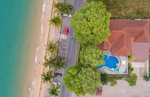 an overhead view of a beach with trees and a house at RimLay Beachfront Pool Villa in Sattahip