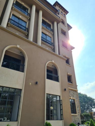 a building with tall columns and windows on it at Fontis Residences Hotel in Kampala