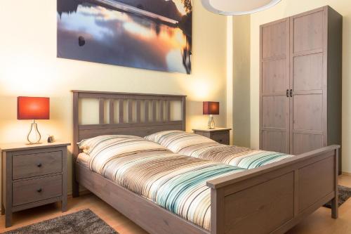 DD-Apartment Löbtau 1 في درسدن: غرفة نوم مع سرير مع مواقف ليلتين ومصباحين