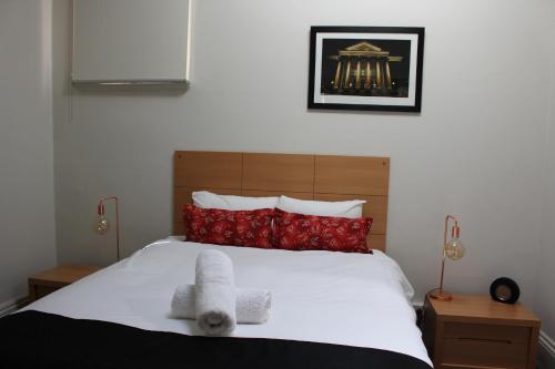 a bedroom with a bed with a teddy bear on it at Abbey View in Bendigo