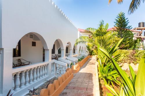 a villa with a swimming pool and palm trees at Amaan Beach Bungalows in Nungwi