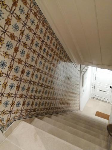 a stairwell with a patterned wall and a stair case at Casa do Coronel de Alcochete in Alcochete