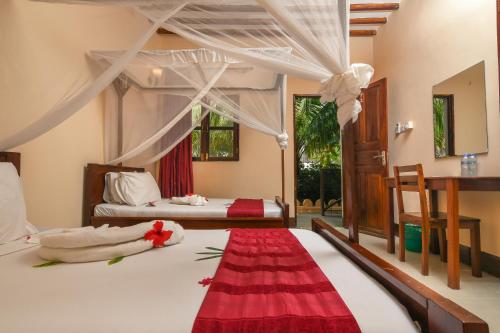 a bedroom with two beds and a red rug at Amaan Beach Bungalows in Nungwi