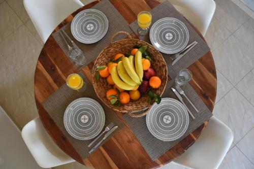 a table with a basket of fruit on it at De_naxia Suites in Perissa