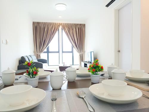 una sala da pranzo con piatti bianchi su un tavolo di Medini Elysia Park , 3 min to Legoland, Netflix By Hint Homestay a Nusajaya