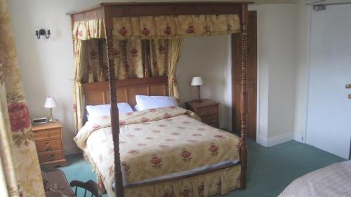 BainbridgeにあるRose & Crown Hotelのベッドルーム1室(天蓋付きベッド1台、ナイトスタンド2台付)